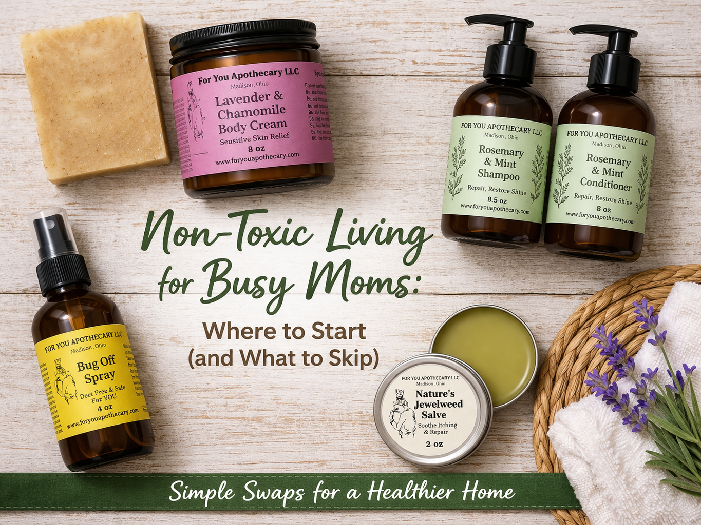 Non-Toxic Living for busy moms with products by For You Apothecary. Contains Sunny Bunny Bar Soap, Lavender & Chamomile Body Cream, Rosemary & mint Hair Care Duo, Bug Off Bug Spray and Natures Jewelweed Salve laying on a wood table with lavender and a towel